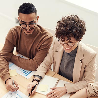 Image of two people seated at a conference table.